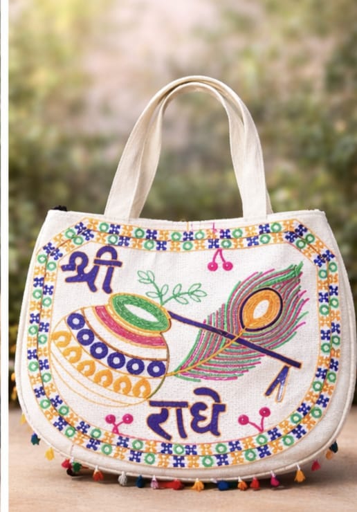 Colorful handbag with peacock feather design and text on a blurred natural background