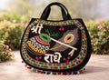 Decorative handbag with intricate patterns and text on a wooden surface with a blurred natural background