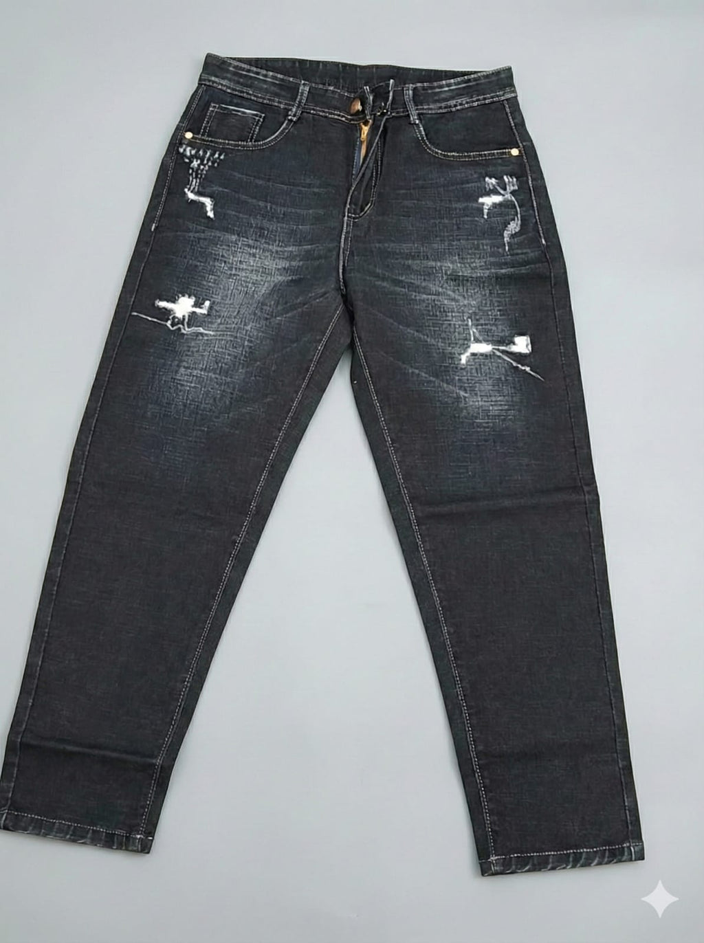 Distressed black jeans on a gray background