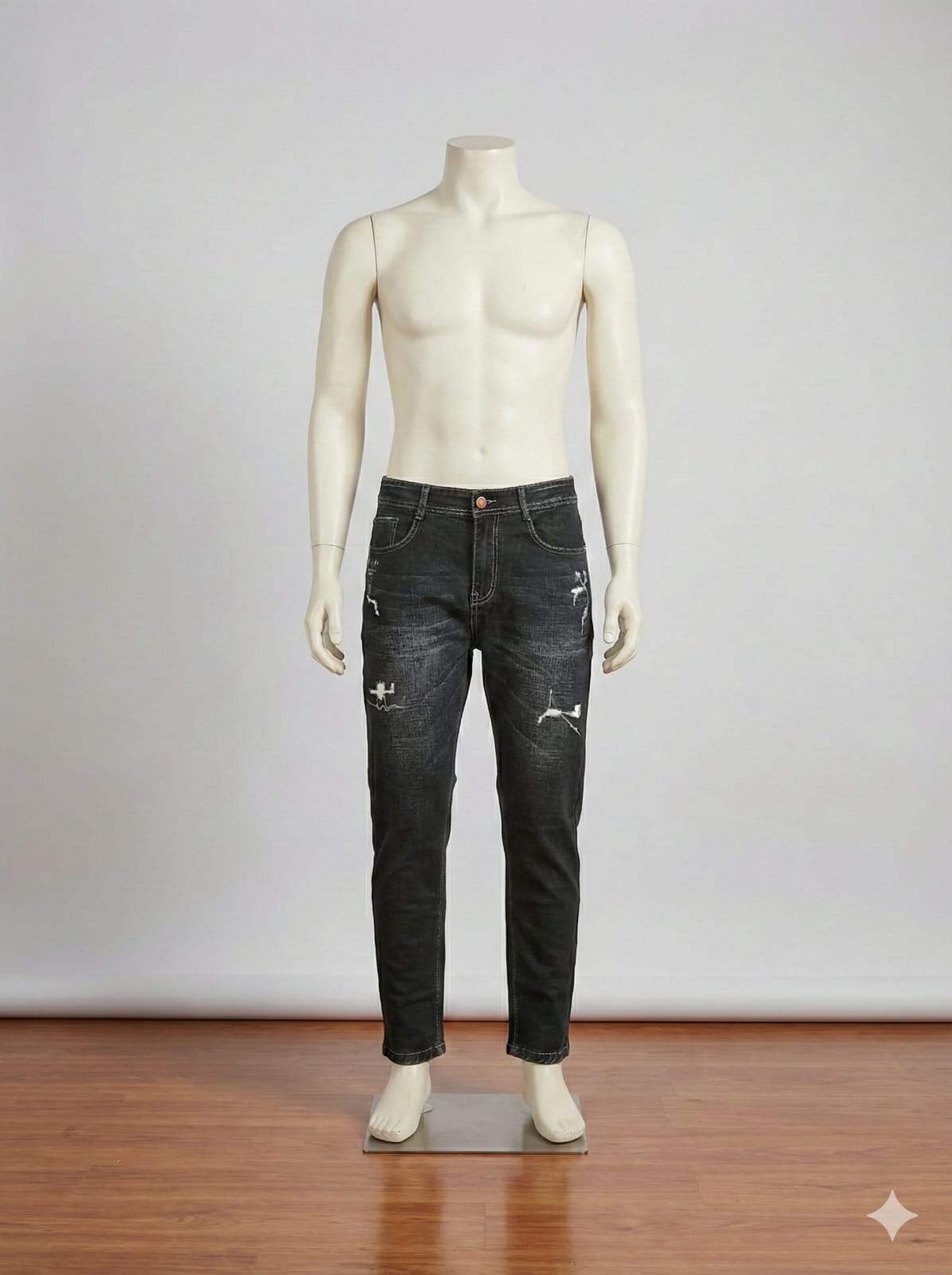 Mannequin wearing black jeans on a wooden floor with a white background