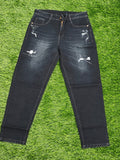 Distressed black jeans on a green grass background