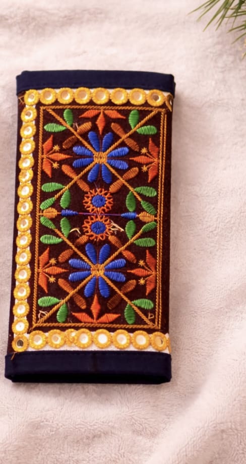 Decorative pouch with floral embroidery and beaded border on a beige background