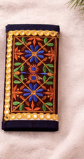 Decorative pouch with floral embroidery and beaded border on a beige background