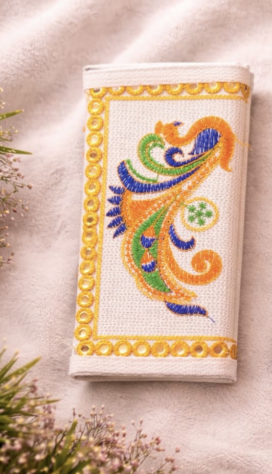 Decorative handmade pouch with colorful embroidery on a textured surface