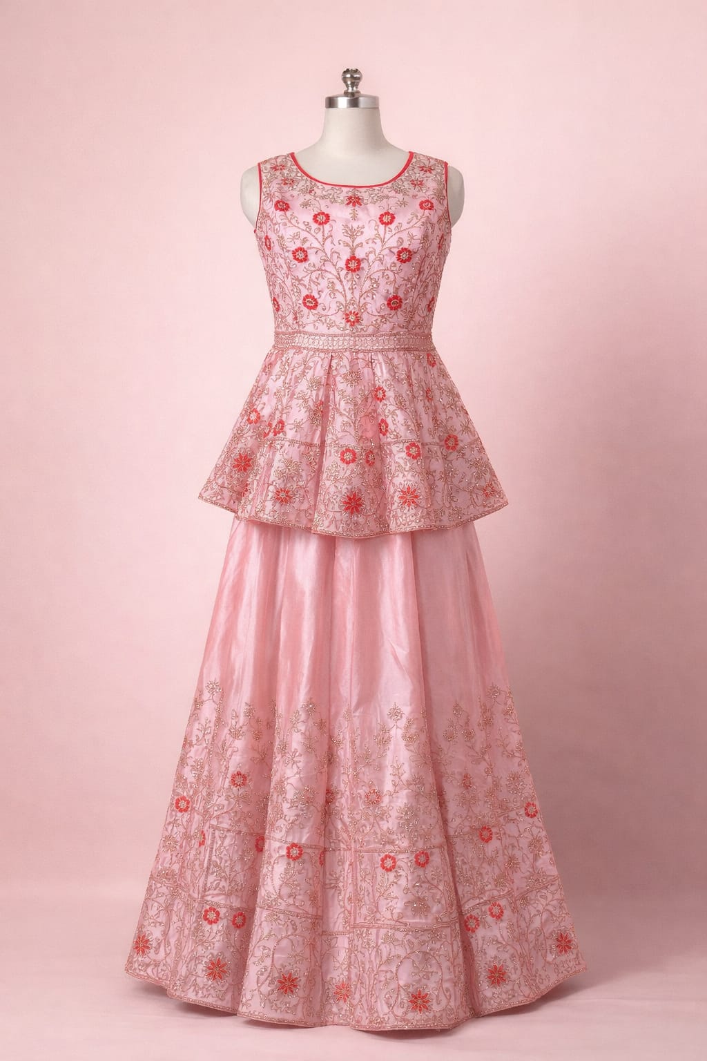 Pink embroidered two-piece dress on a mannequin against a pink background