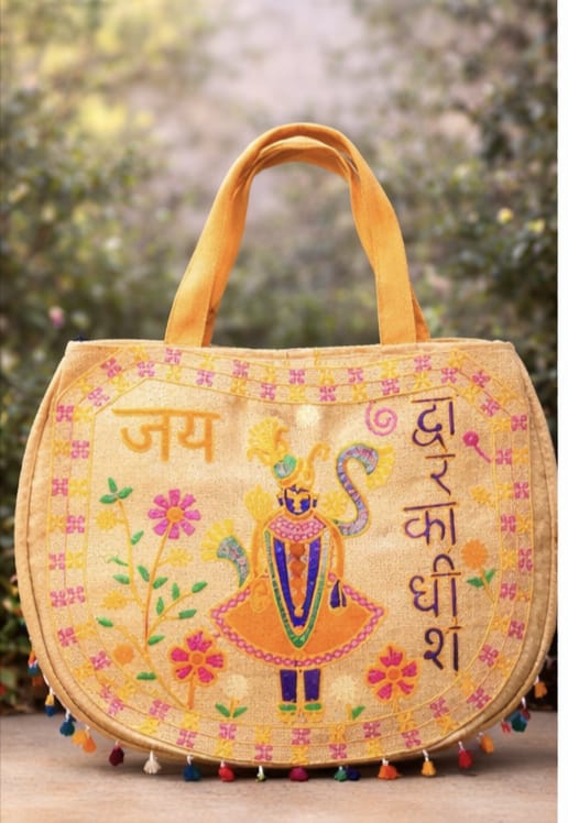 Colorful embroidered bag with intricate designs and text, set against a natural background.